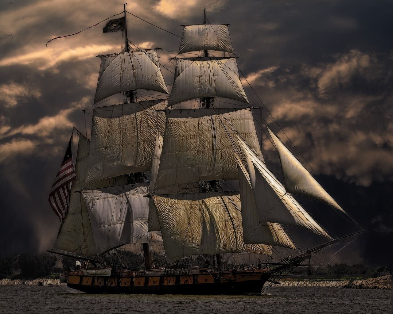A large sail boat sailing on the ocean under cloudy skies.