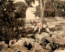A man and woman in the woods near rocks.
