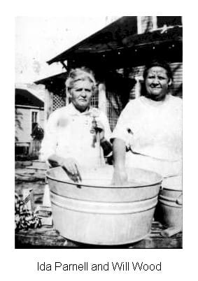Two women standing next to a large metal tub.
