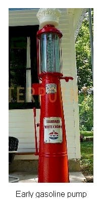 A red gas pump sitting on the side of a house.