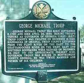 A historical marker in front of the river.