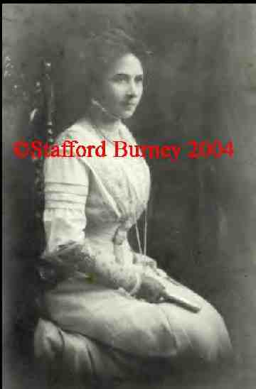 A woman in white dress sitting on the ground.