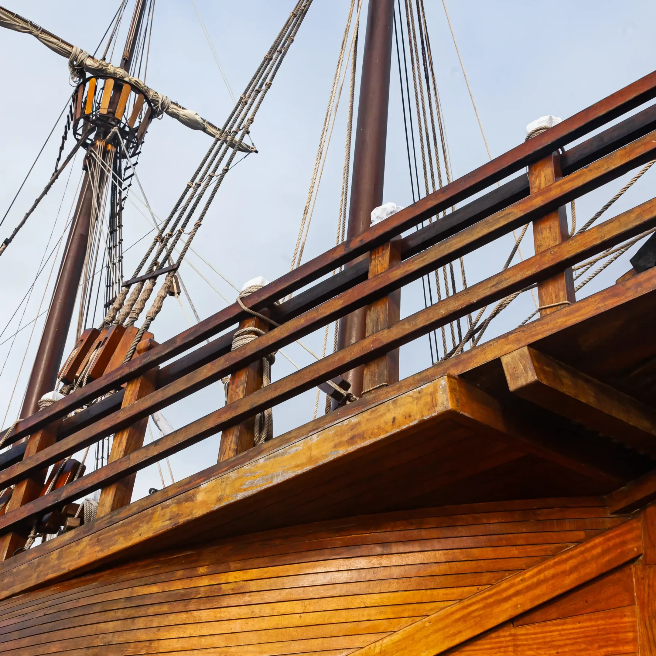 A wooden boat with a large sail on it.